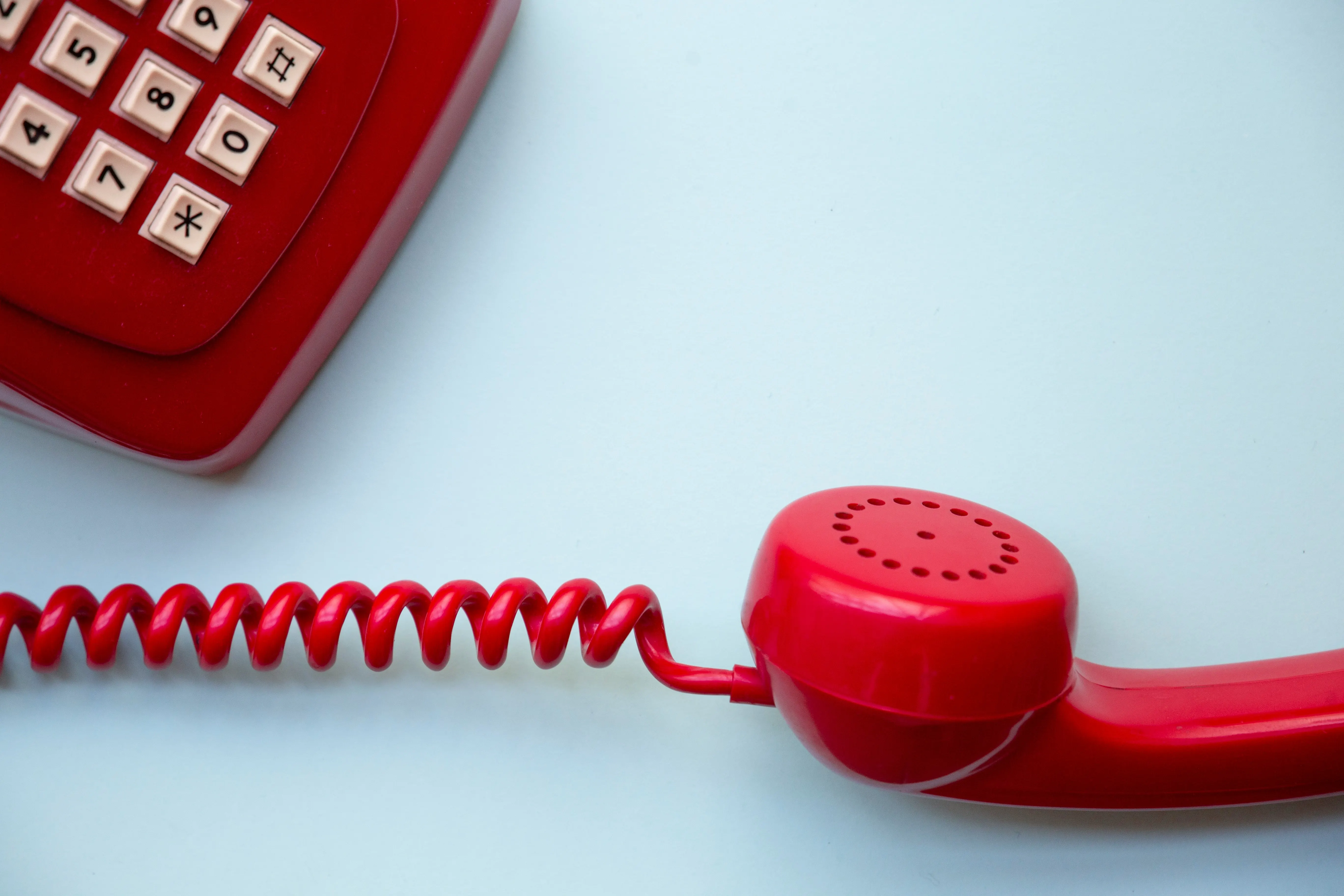 Red vintage telephone on a pale background