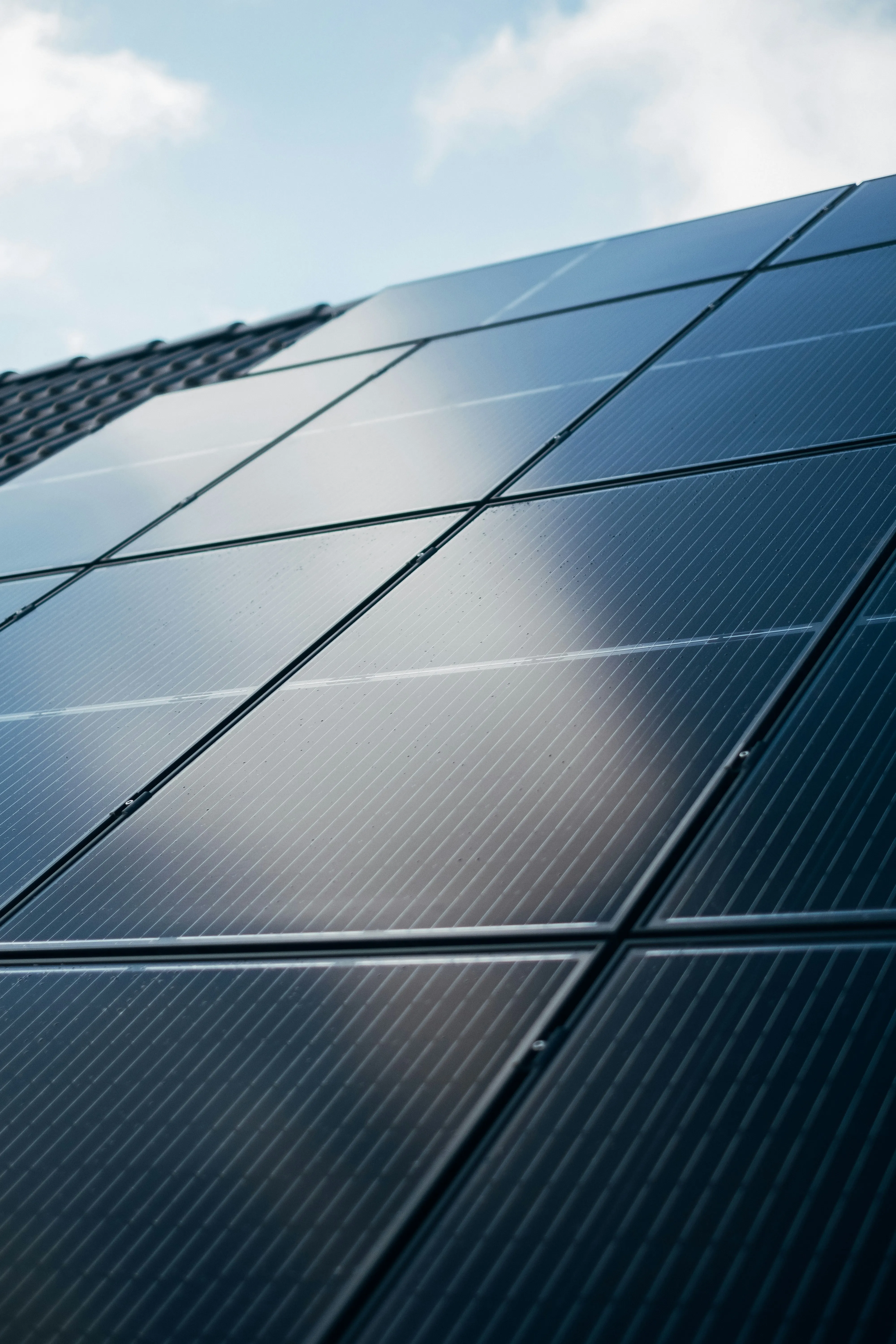 Rows of solar panels angled toward a bright sky